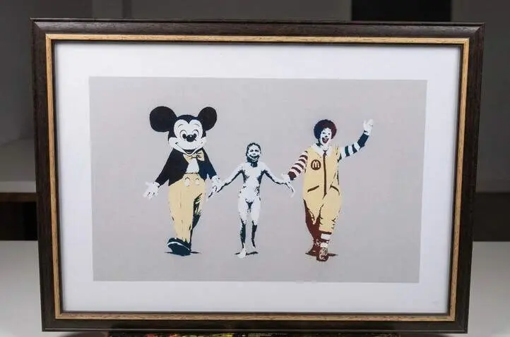 The Terror of War (1972) de Nick Ut, mostrando a la ni&ntilde;a Phan Thị Kim Ph&uacute;c, v&iacute;ctima del napalm en la Guerra de Vietnam, tomada de las manos de Mickey Mouse y Ronald McDonald.